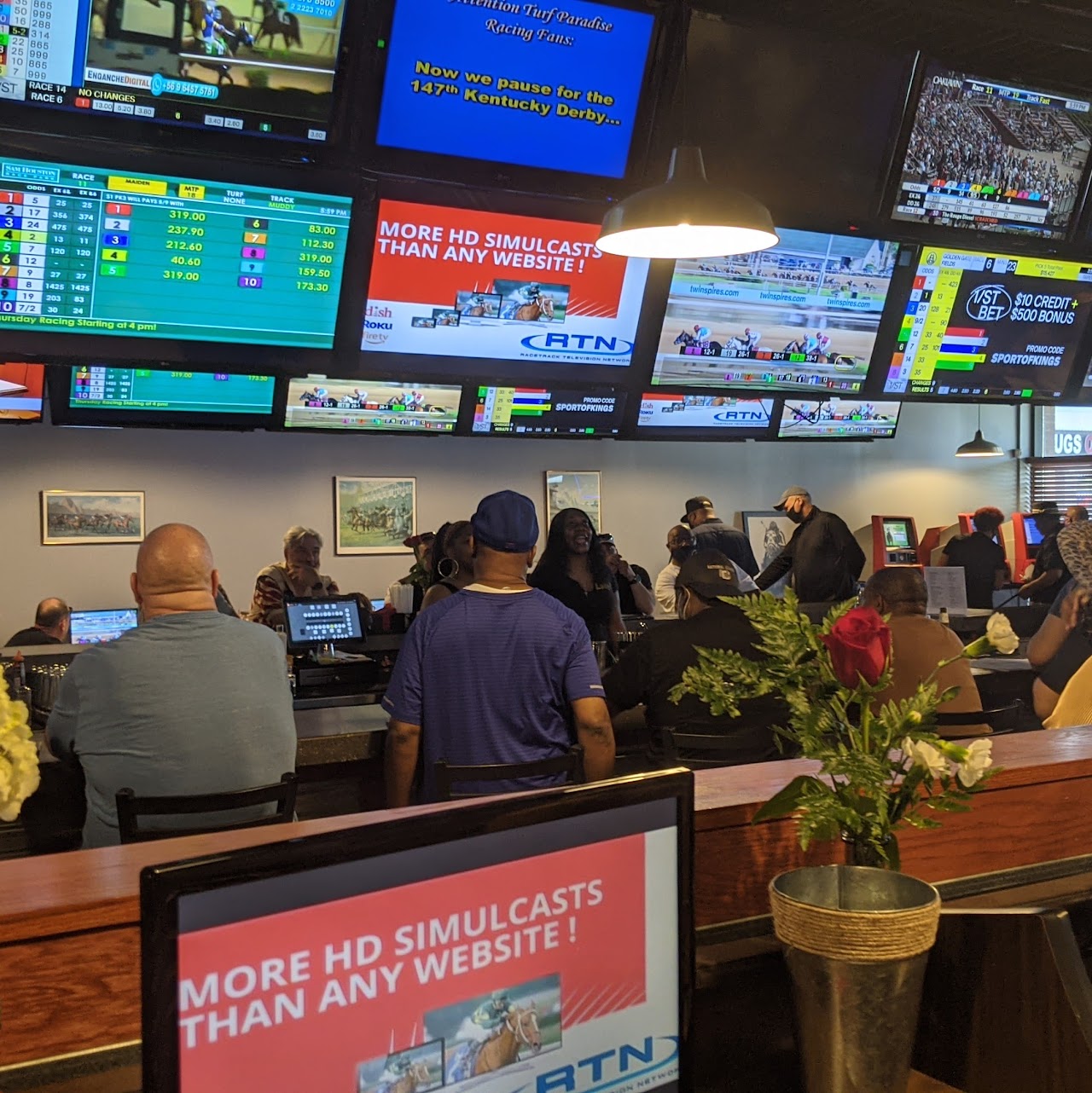 Black Eyed Susan Lansing sports betting area with customers watching racing on multiple screens